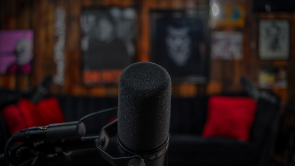 Podcast studio with comedy poster backdrop